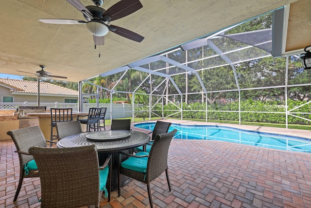 view of pool with a patio area, an outdoor bar, and glass enclosure