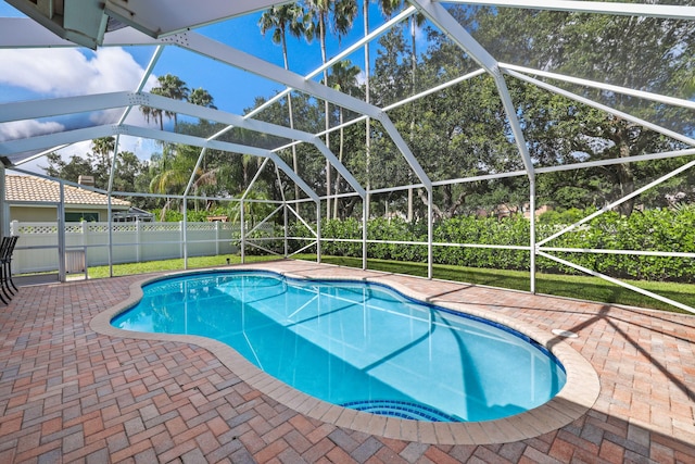 view of pool with glass enclosure and a patio area