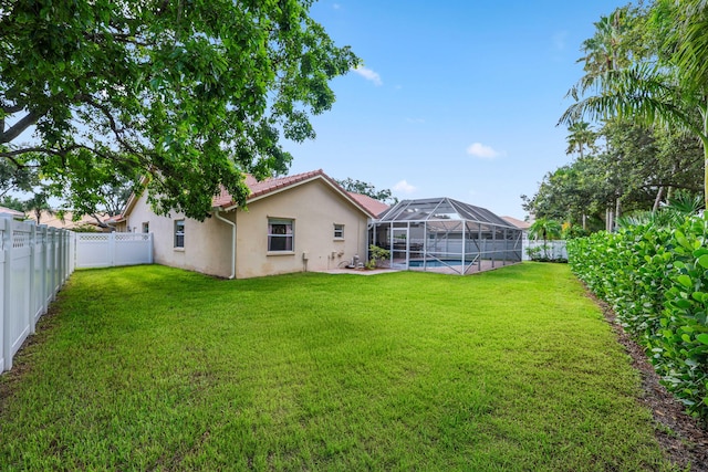 view of yard featuring glass enclosure and a fenced in pool