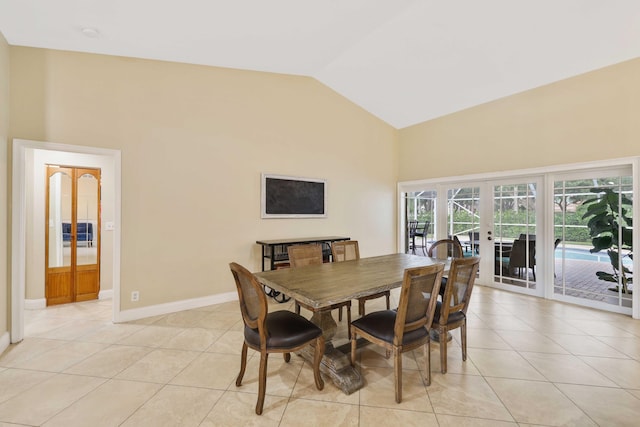 tiled dining space featuring french doors and vaulted ceiling