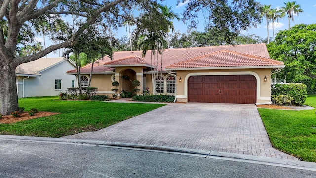 mediterranean / spanish-style home featuring a front yard and a garage