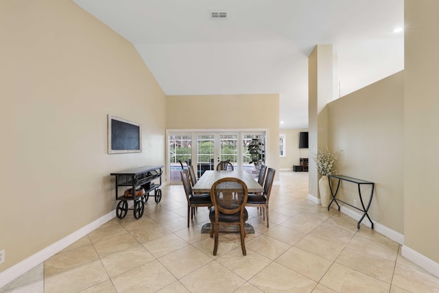 dining space with light tile patterned flooring and lofted ceiling