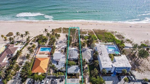 drone / aerial view with a beach view and a water view