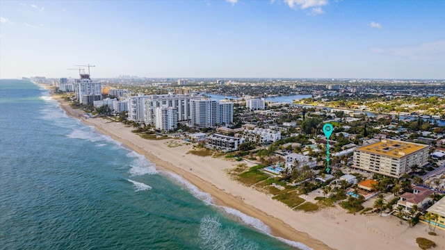 birds eye view of property with a water view and a beach view