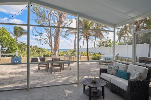 sunroom featuring a water view and vaulted ceiling