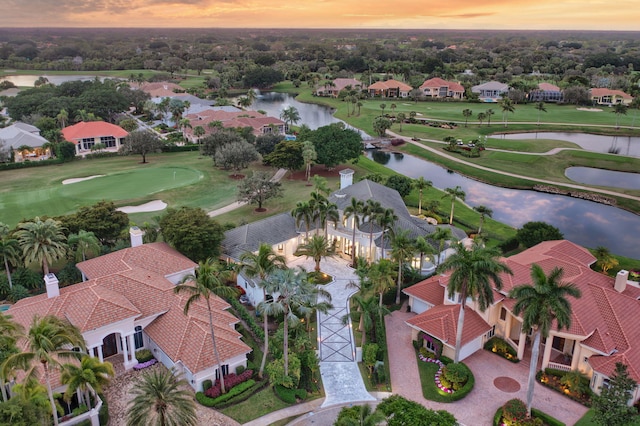 aerial view at dusk featuring a water view