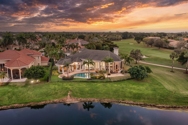 aerial view at dusk featuring a water view