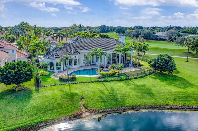 back of house with a lawn and a water view