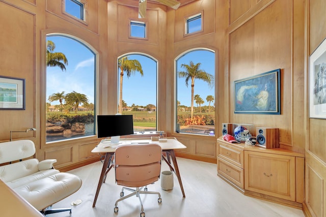 office area with wood walls and a high ceiling