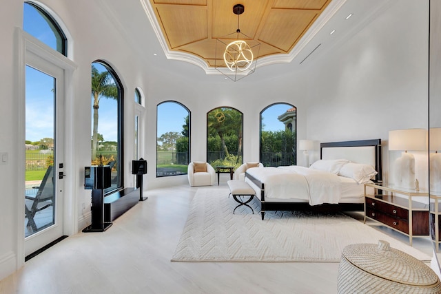 bedroom with access to outside, multiple windows, a tray ceiling, and wooden ceiling