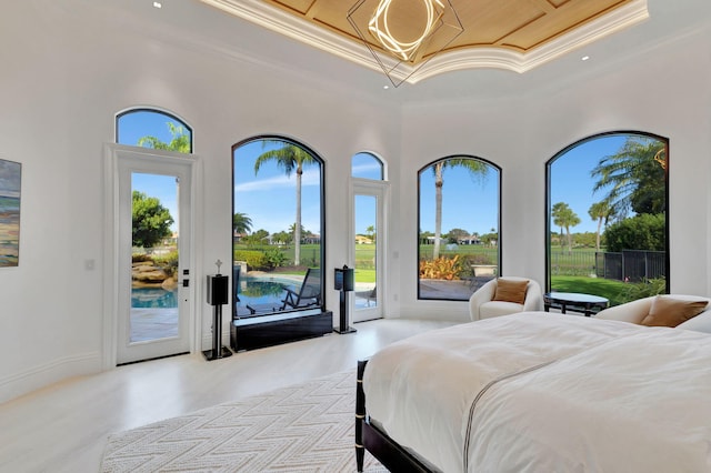 bedroom with access to exterior, a high ceiling, a tray ceiling, and ornamental molding