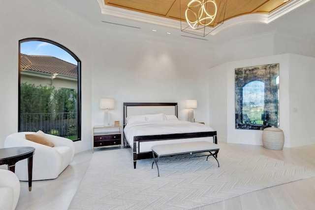 bedroom featuring a tray ceiling, crown molding, and light wood-type flooring