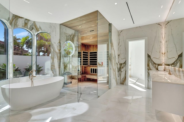 bathroom with a tub to relax in and vanity