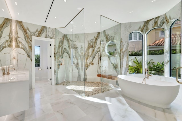 bathroom with tile walls, independent shower and bath, and sink