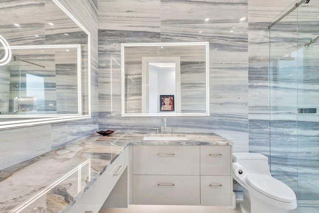 bathroom with tile walls, vanity, an enclosed shower, and toilet