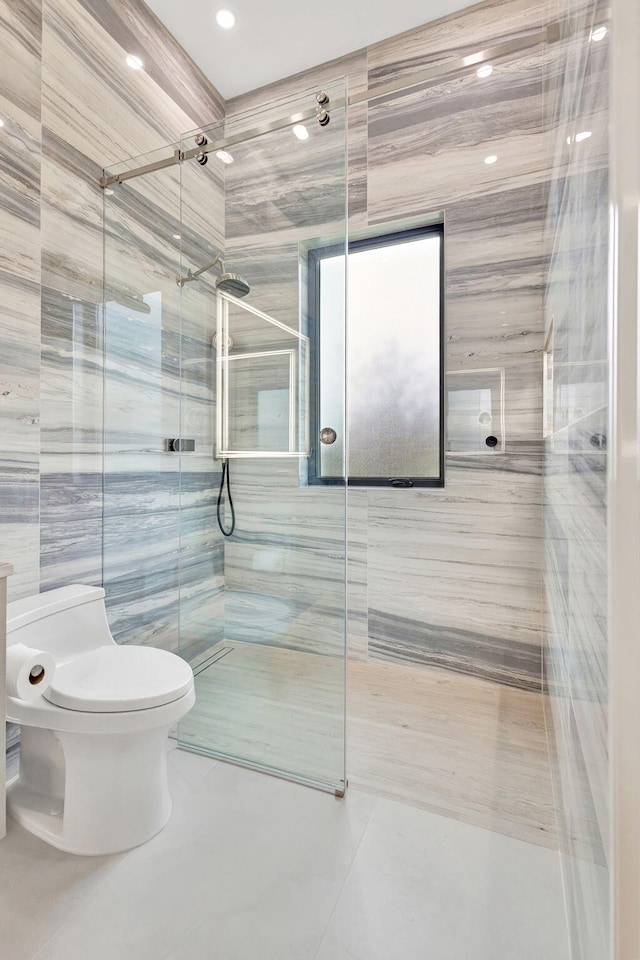 bathroom with toilet, walk in shower, and tile walls