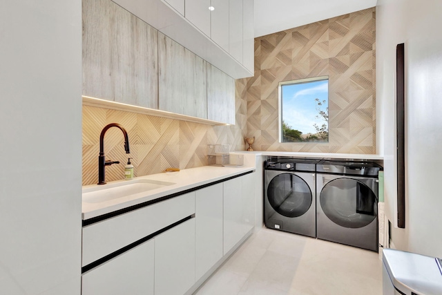 washroom featuring washer and dryer, light tile patterned floors, cabinets, and sink