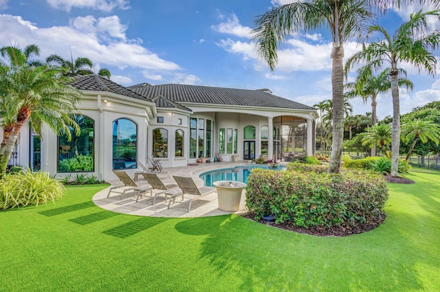 back of property with a lawn, a patio, and french doors