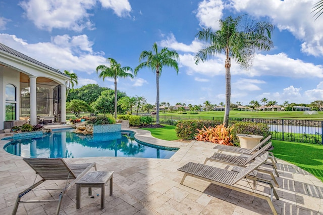 view of swimming pool with a lawn, a patio area, and a water view