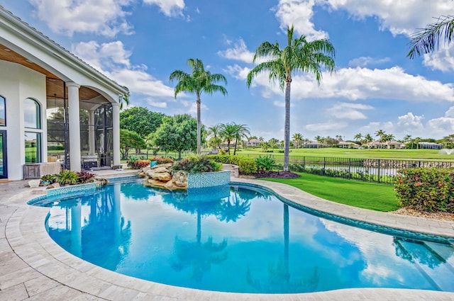 view of swimming pool featuring a yard, a water view, and a sunroom