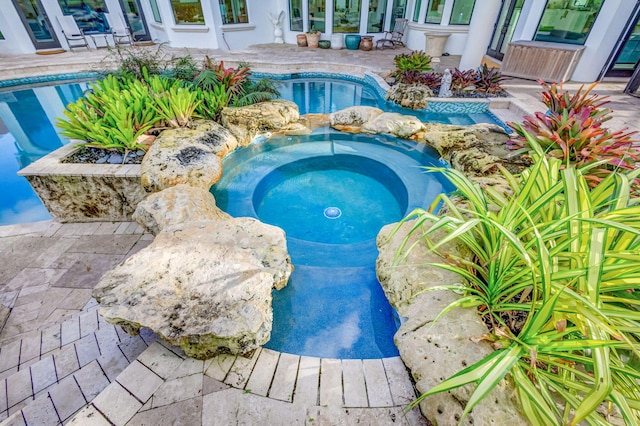 view of swimming pool with an in ground hot tub