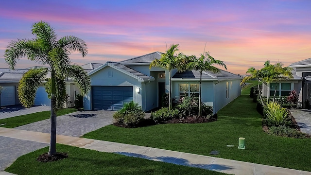 single story home with a garage and a lawn