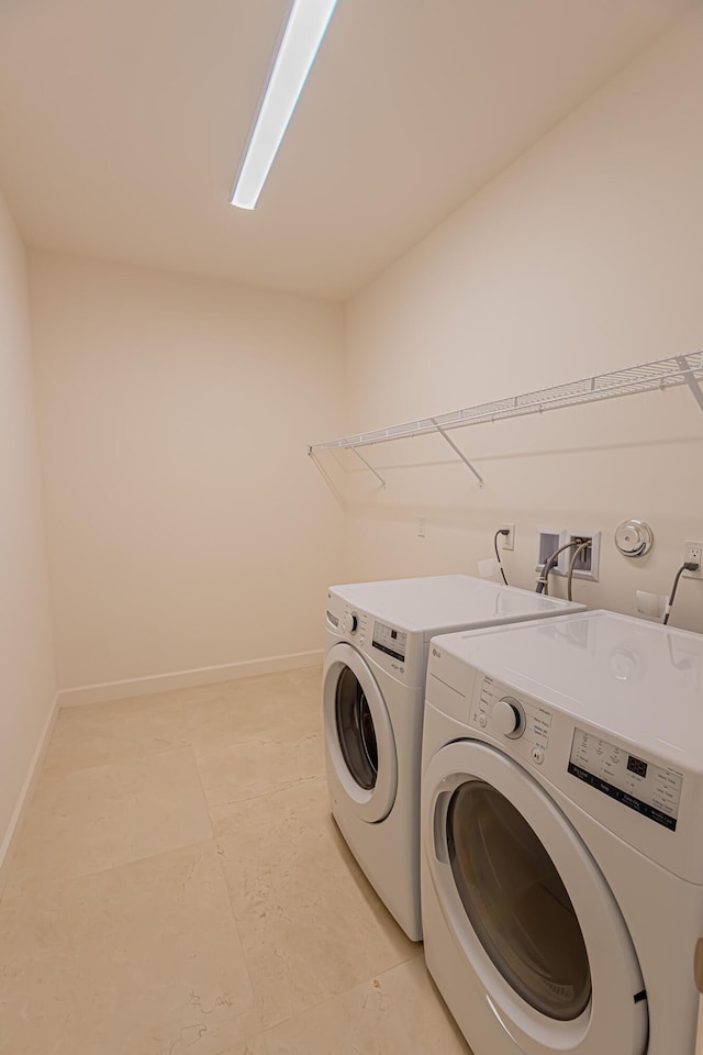 clothes washing area with separate washer and dryer and light tile patterned floors