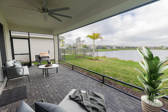 sunroom with a water view and ceiling fan