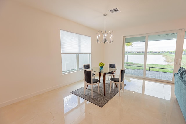 dining area featuring a water view and a chandelier