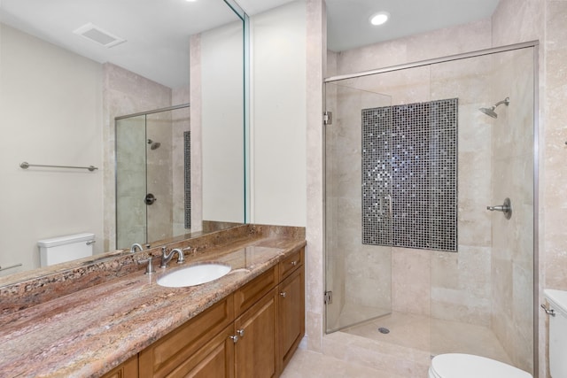 bathroom featuring tile patterned floors, a shower with door, vanity, and toilet