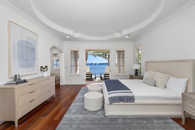 bedroom featuring dark hardwood / wood-style flooring, ornamental molding, and a tray ceiling