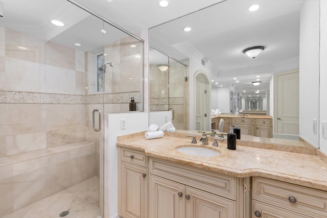 bathroom featuring vanity, an enclosed shower, and ornamental molding