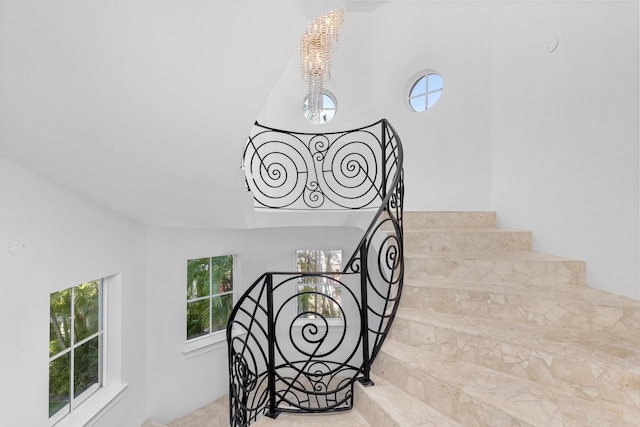 stairway with a notable chandelier