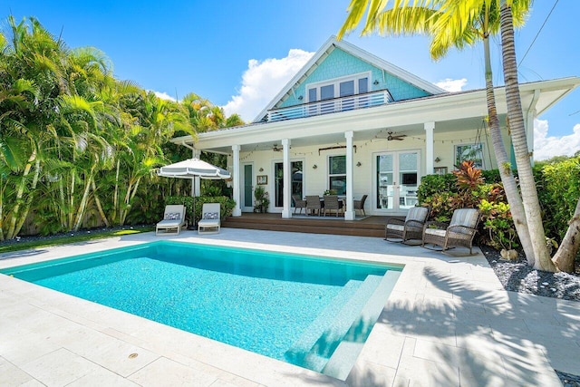 view of pool featuring ceiling fan, a patio area, a wooden deck, and french doors