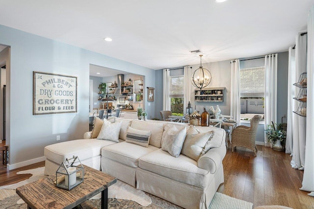 living room with hardwood / wood-style flooring, a healthy amount of sunlight, and a chandelier