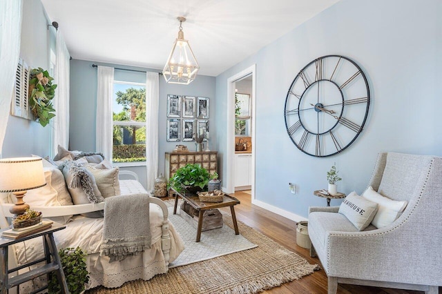 living area with an inviting chandelier and hardwood / wood-style flooring