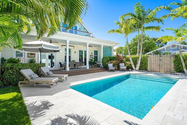 view of swimming pool with ceiling fan, a patio area, and a deck