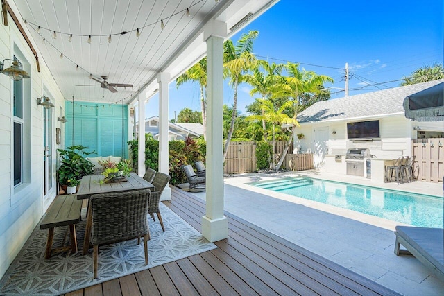 view of swimming pool with ceiling fan, a patio area, exterior kitchen, and a wooden deck