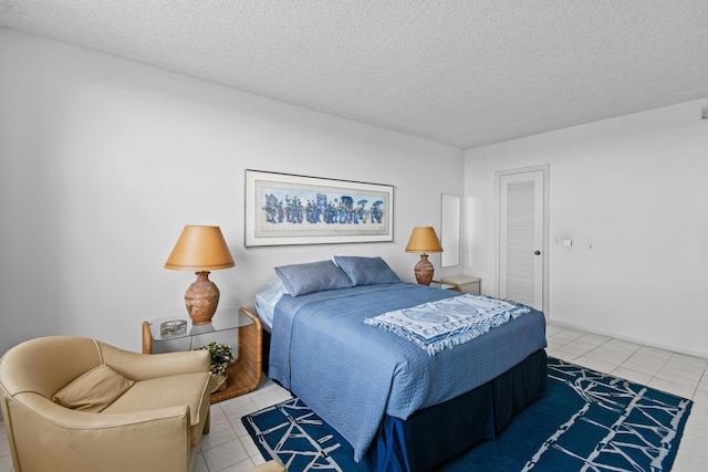 tiled bedroom with a closet and a textured ceiling