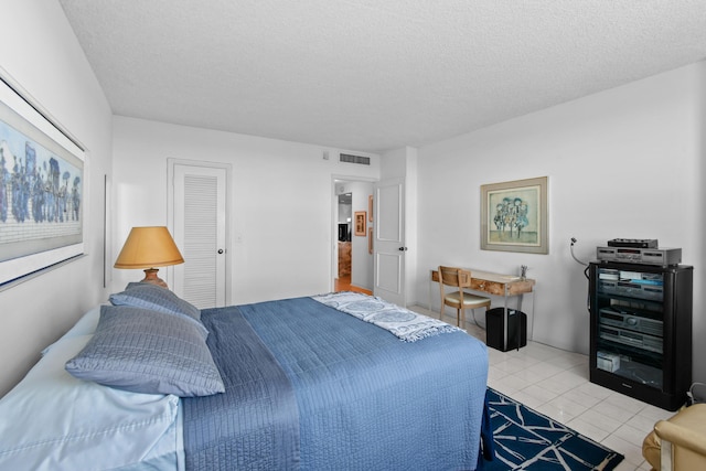 tiled bedroom with a textured ceiling