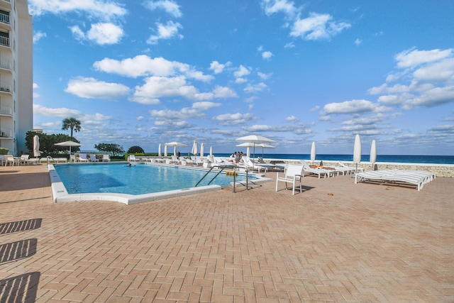 view of swimming pool featuring a patio area and a water view