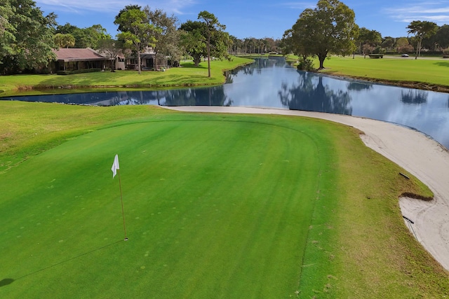 view of property's community with a water view and a lawn