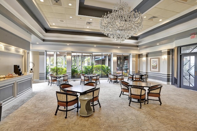 dining space with a raised ceiling, a high ceiling, light carpet, and an inviting chandelier