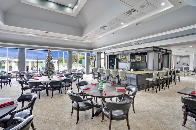 dining room featuring a towering ceiling, ornamental molding, light colored carpet, a raised ceiling, and bar area