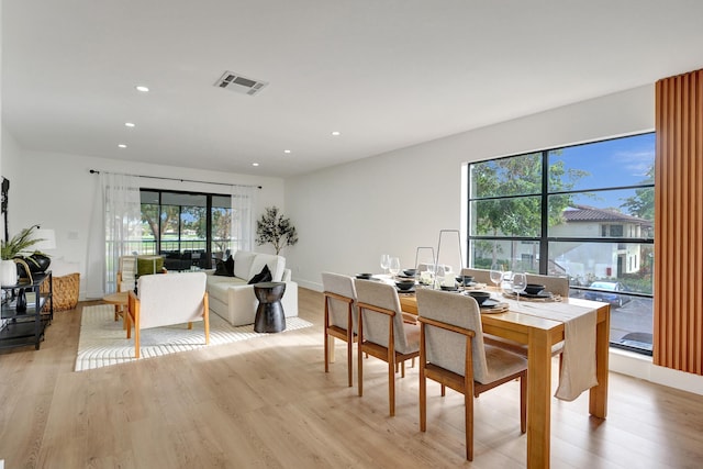 dining area with a wealth of natural light and light wood-type flooring