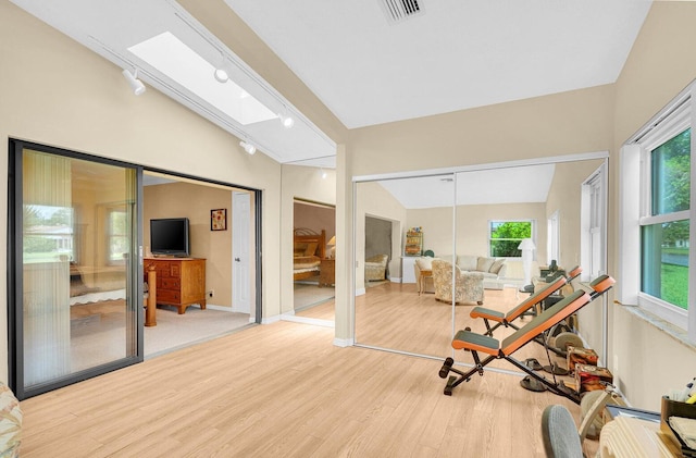 sunroom featuring lofted ceiling with skylight and a wealth of natural light