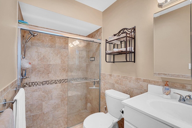 bathroom with radiator, vanity, tile walls, toilet, and a shower with shower door