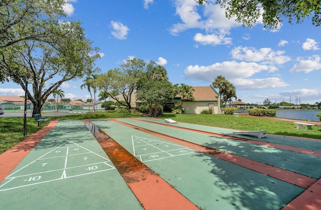 view of community with a water view and a yard