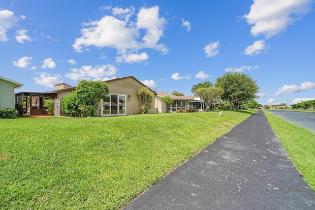 view of front of house featuring a water view and a front lawn