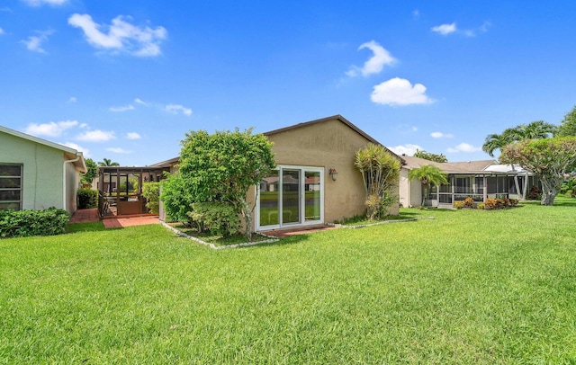 back of property with a sunroom and a yard